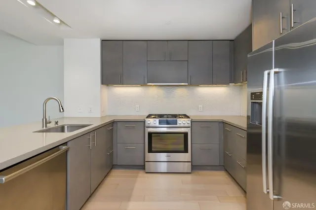 a kitchen with a stove top oven and refrigerator