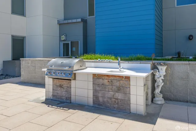a roof deck with table and chairs a barbeque
