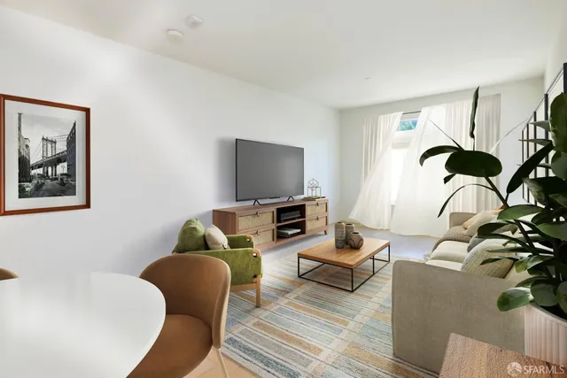 a living room with stainless steel appliances furniture a window and a kitchen island