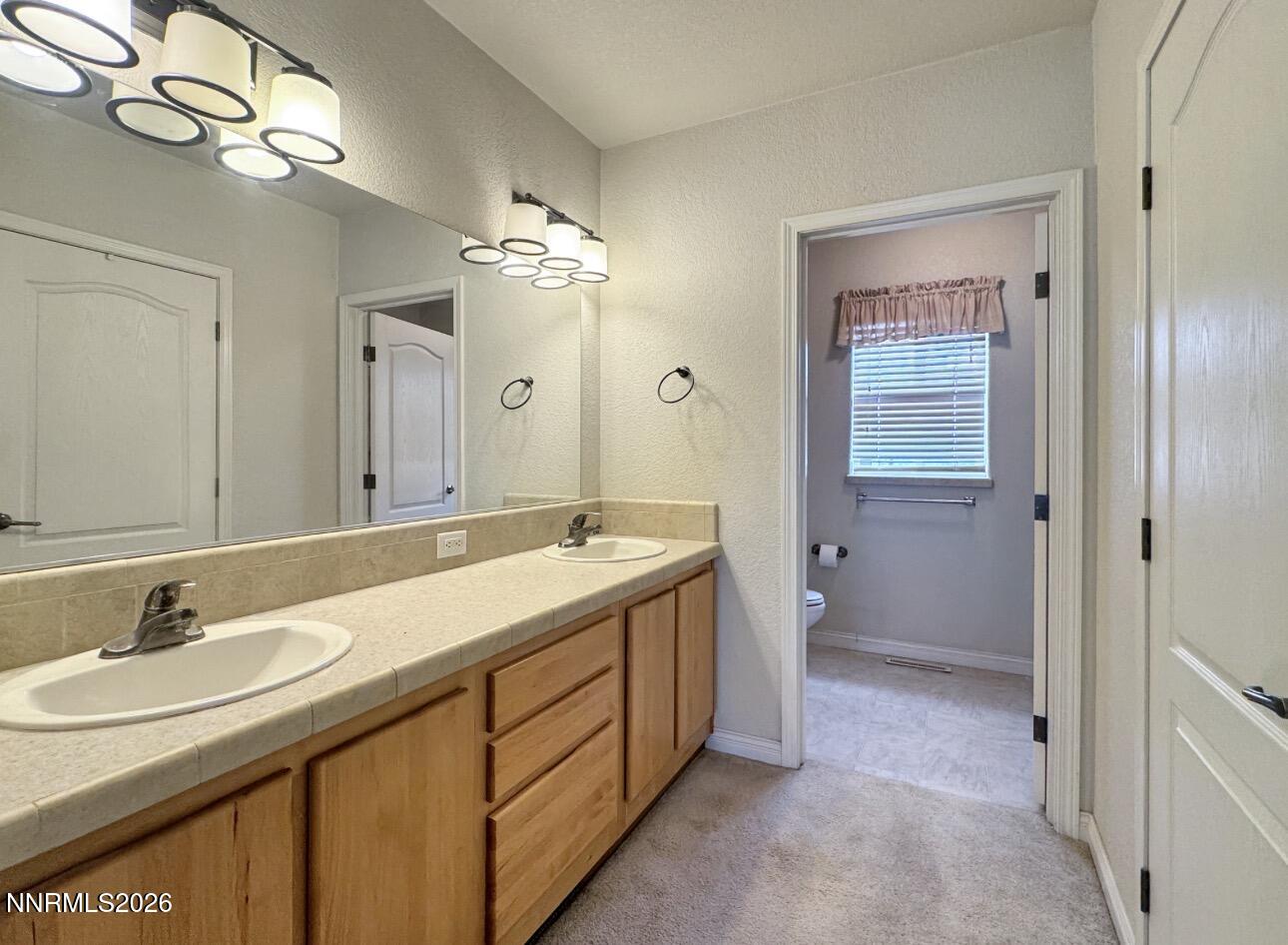 5695 Mote Road Battle Mountain, NV 89820 - Photo 12 of 16 a spacious bathroom with a granite countertop sink a mirror and a shower
