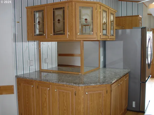 a kitchen with stainless steel appliances granite countertop a refrigerator a stove and a sink