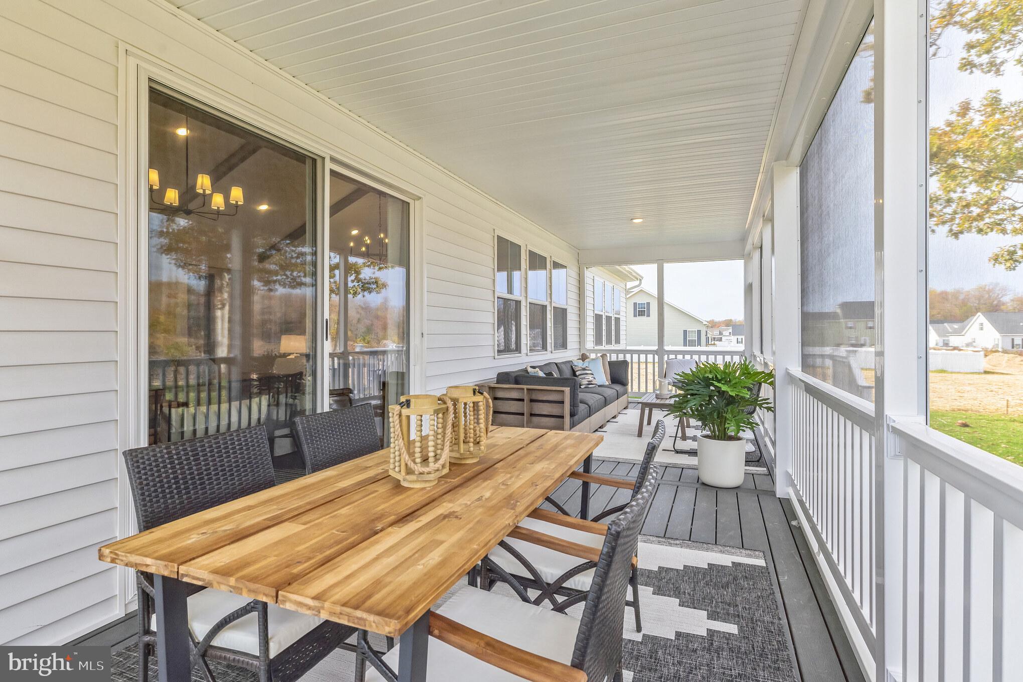 36319 Gate Drive Georgetown, DE 19947 - Photo 17 of 28 a view of a patio with a dining table and chairs with wooden floor
