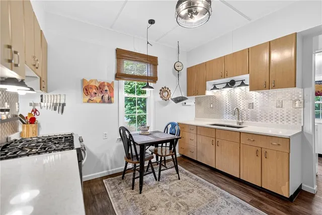 a kitchen with stainless steel appliances a table chairs and a refrigerator