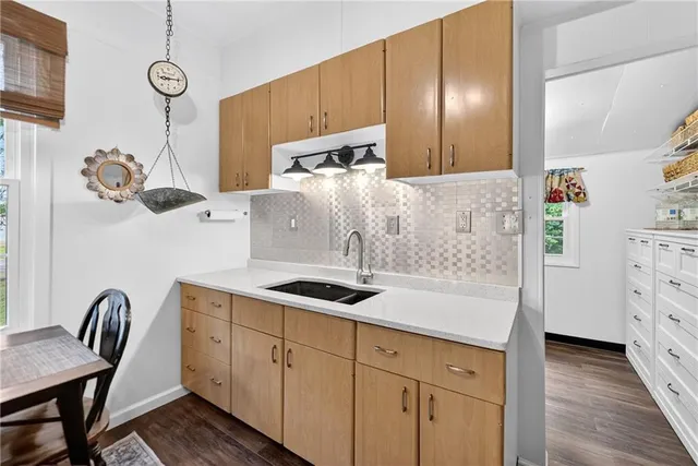 a bathroom with a granite countertop sink a mirror and shower