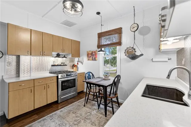 a kitchen with stainless steel appliances granite countertop a sink a stove and a refrigerator