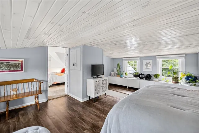 a large bedroom with a bed and a flat screen tv