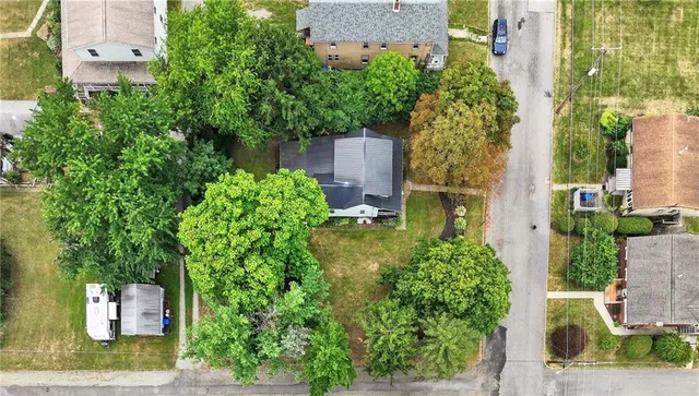 a backyard of a house with barbeque oven and trees