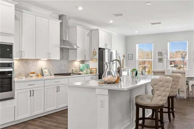 a kitchen with granite countertop a white stove top oven a sink a counter space and cabinets