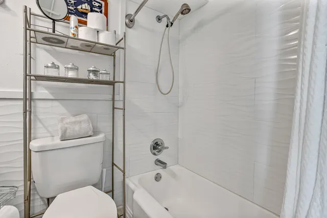 a bathroom with a granite countertop sink a toilet and a mirror