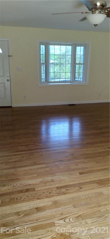 127 Wildcat Road, Unit C Lancaster, SC 29720 - Photo 3 of 15 an empty room with wooden floor and windows