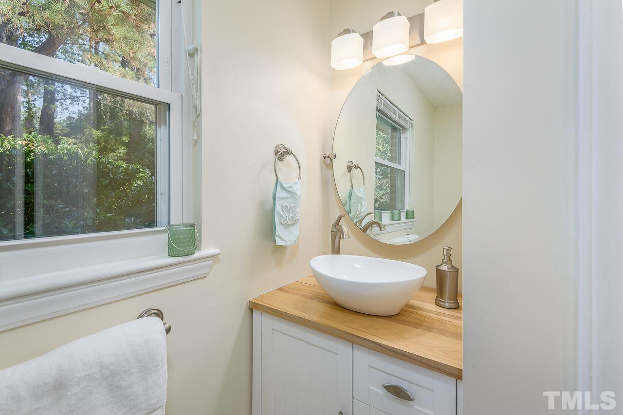 4105 Suitt Road Durham, NC 27703 - Photo 13 of 15 a bathroom with a granite countertop sink and a mirror