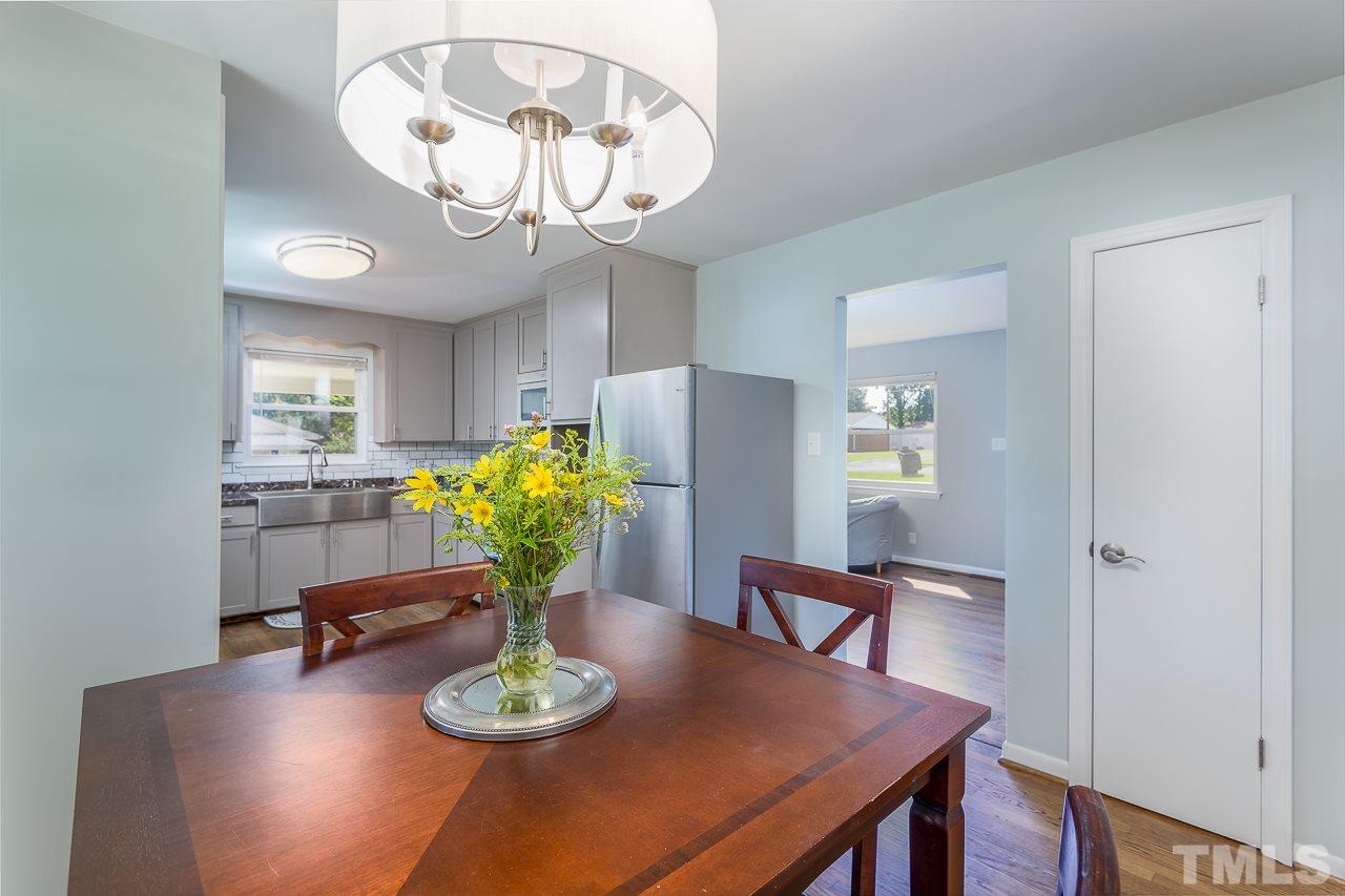 4105 Suitt Road Durham, NC 27703 - Photo 5 of 15 a view of a dining room with furniture a chandelier and wooden floor