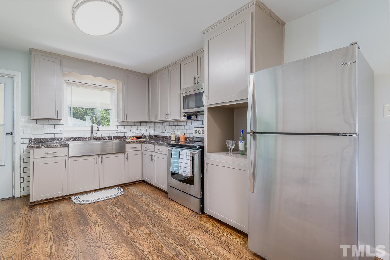 4105 Suitt Road Durham, NC 27703 - Photo 6 of 15 a kitchen with white cabinets and white appliances