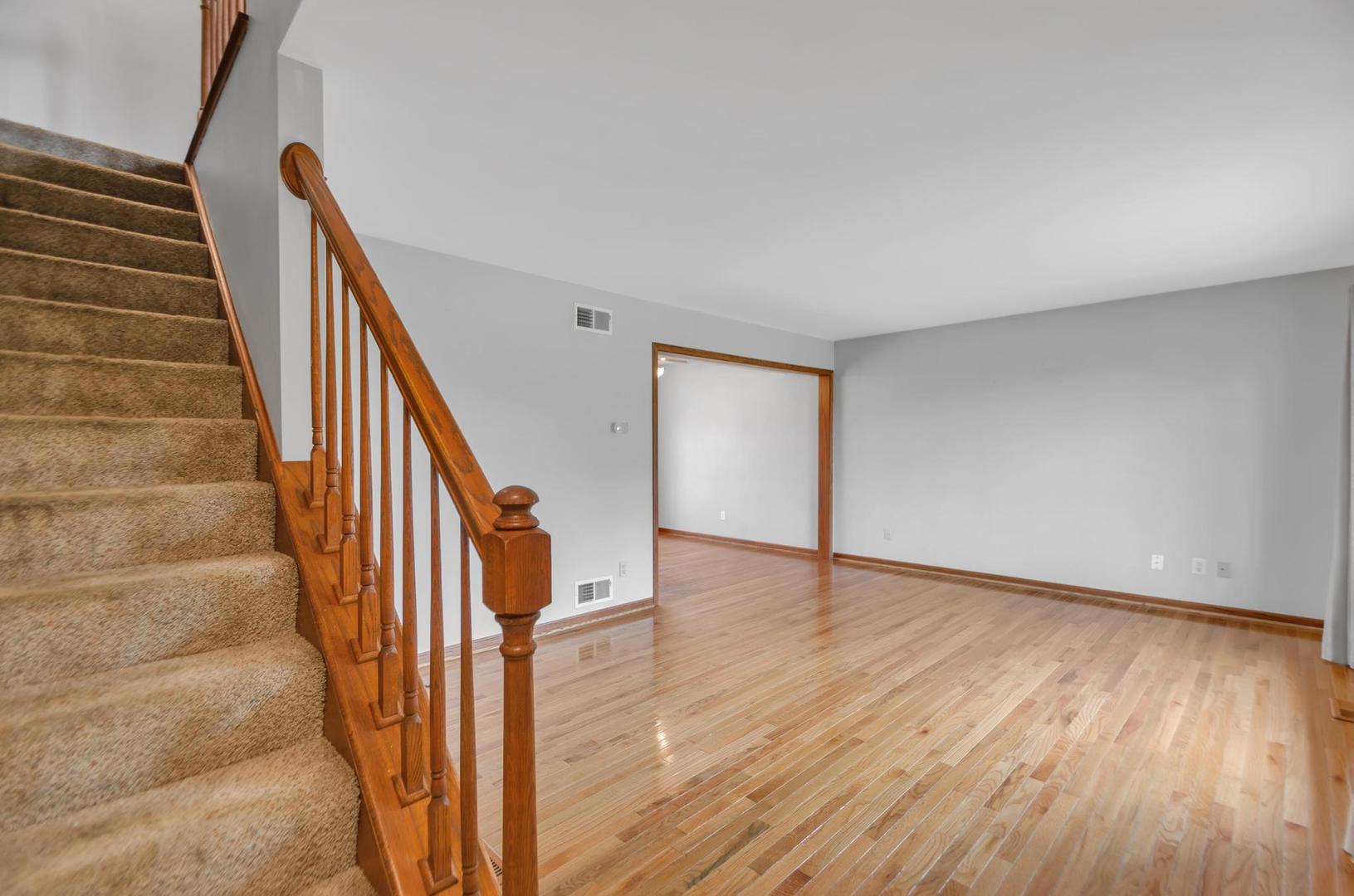 722 Sojourn Road New Lenox, IL 60451 - Photo 12 of 23 a view of an entryway with wooden floor and stairs