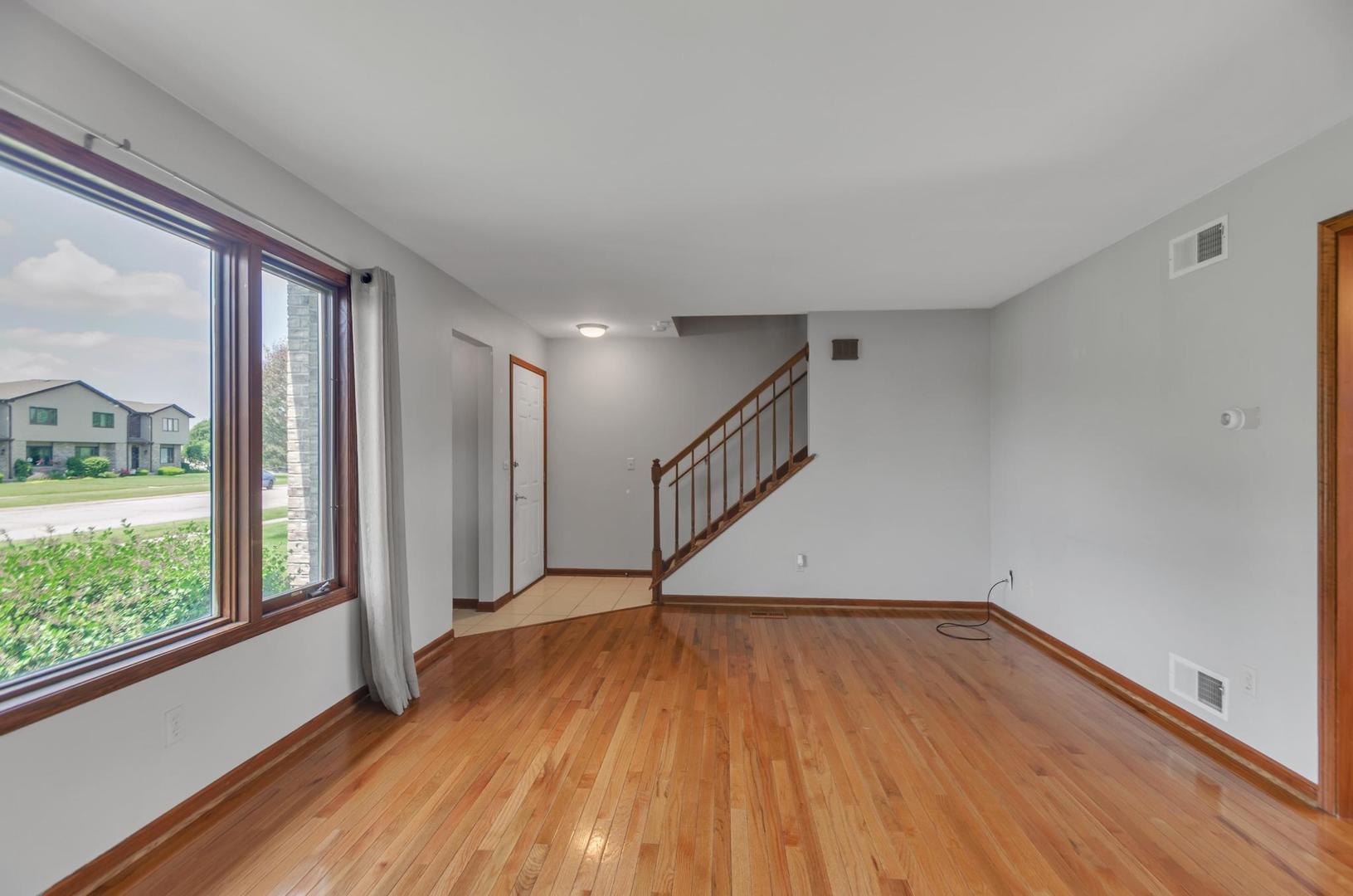 722 Sojourn Road New Lenox, IL 60451 - Photo 7 of 23 a view of empty room with wooden floor and fan