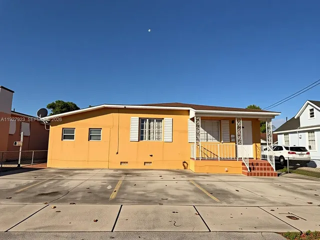 a front view of a house with a road