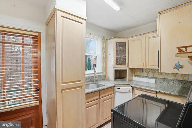 a kitchen with granite countertop cabinets stainless steel appliances a sink and a window