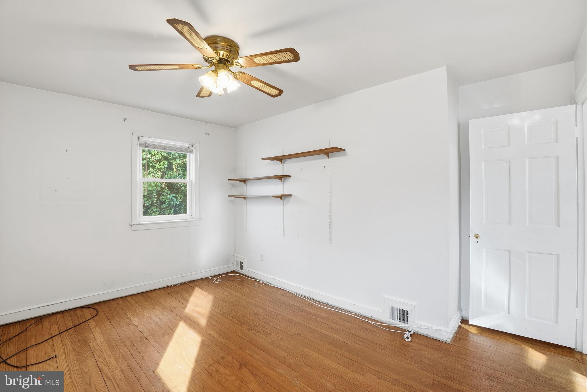 6758 Eastern Avenue Northwest Washington, DC 20012 - Photo 16 of 35 an empty room with wooden floor chandelier fan and windows