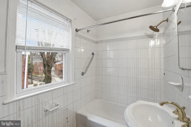 a bathroom with a sink a window and a shower