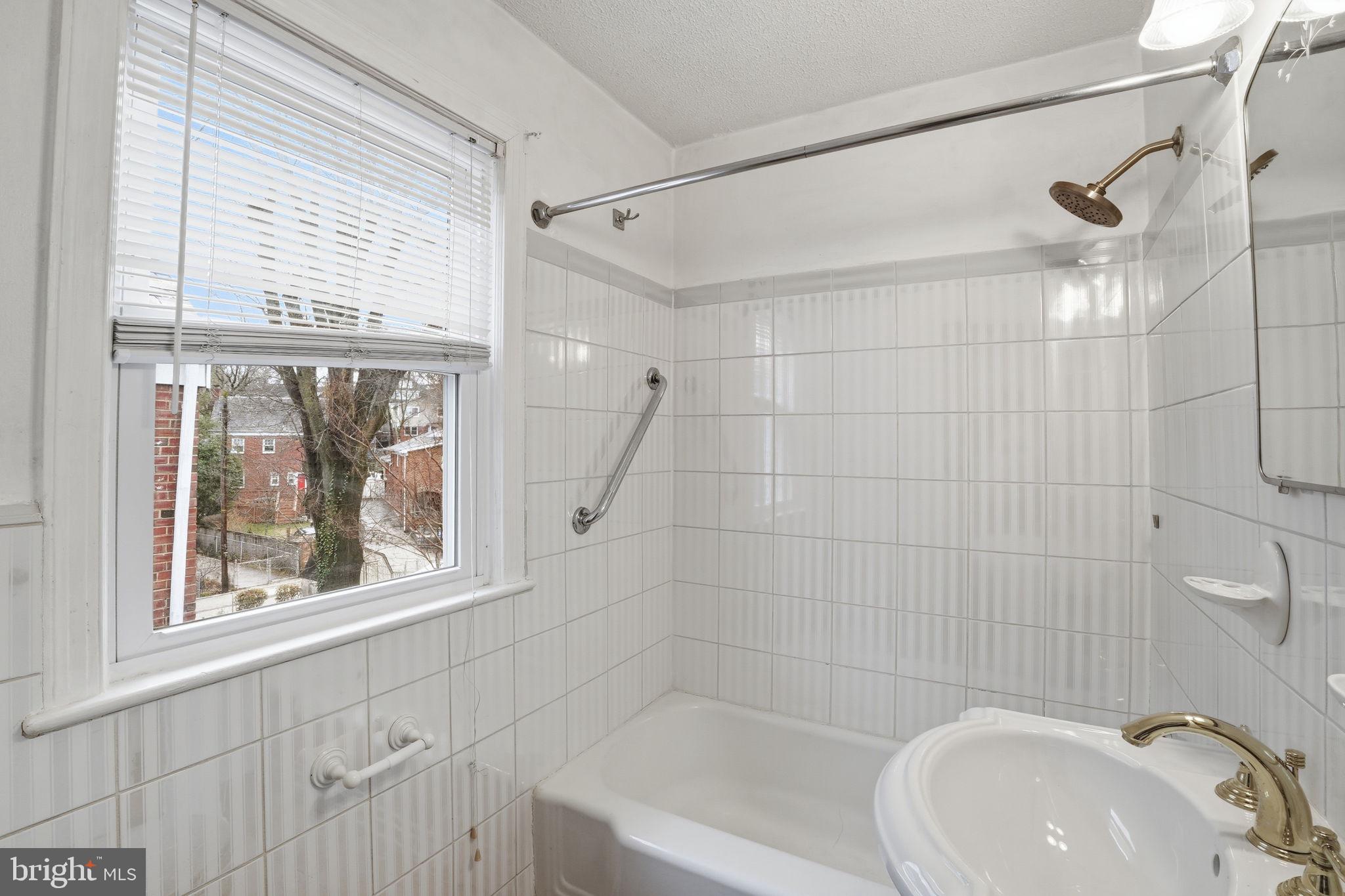 6758 Eastern Avenue Northwest Washington, DC 20012 - Photo 22 of 35 a bathroom with a sink a window and a shower