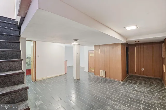 a view of an empty room with wooden floor and entryway