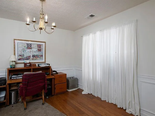 a view of a workspace with furniture and wooden floor