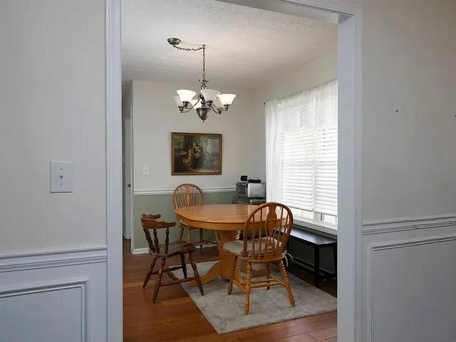 a dining room with furniture a chandelier and wooden floor