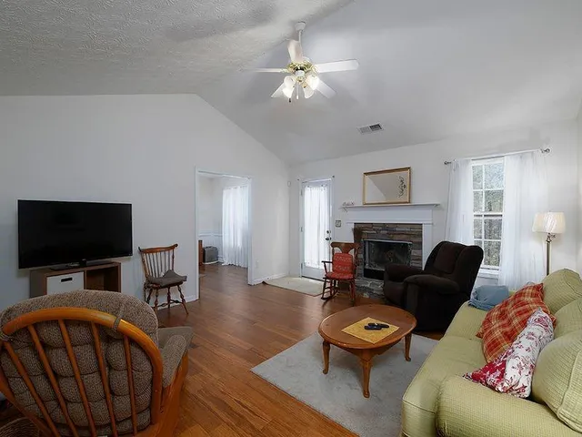 a living room with furniture a fireplace and a flat screen tv