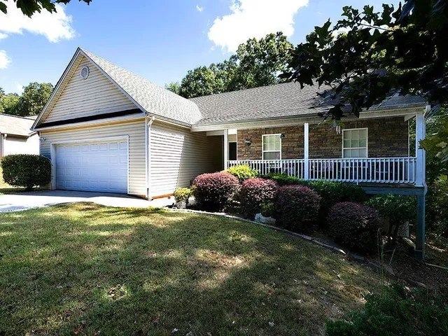 a front view of a house with garden and porch