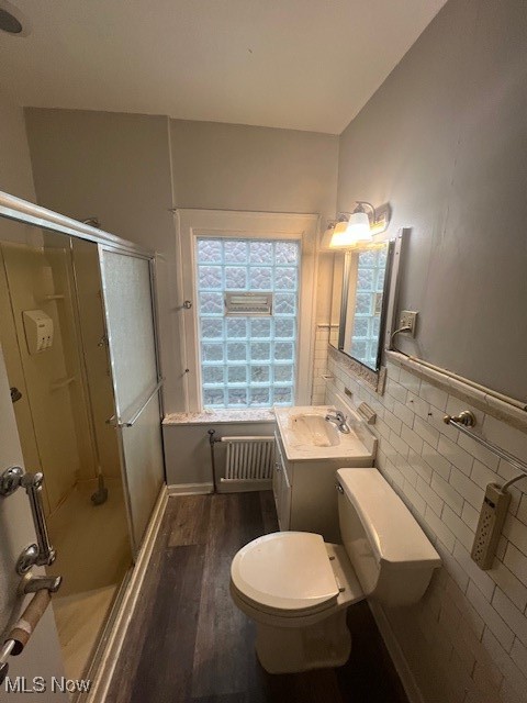 2915 Ludlow Road Cleveland, OH 44120 - Photo 47 of 50 Bathroom with a shower with shower door, radiator heating unit, vanity, tile walls, and dark wood-style flooring
