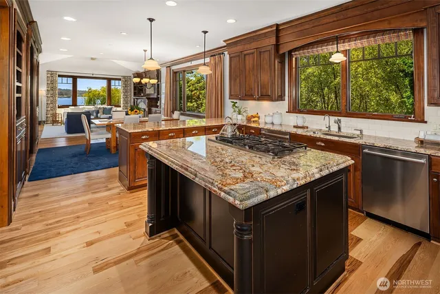 a kitchen with stainless steel appliances granite countertop a stove a sink and a microwave