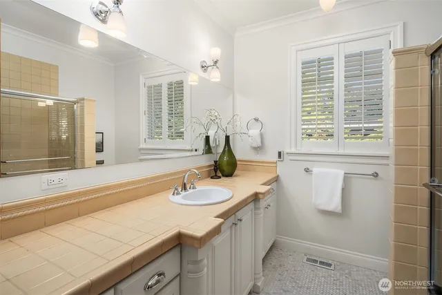 a bathroom with a granite countertop sink and a mirror
