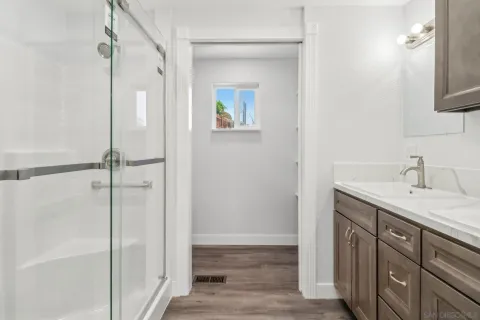 a bathroom with a shower sink and mirror