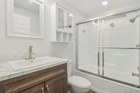 a bathroom with a sink a toilet and shower