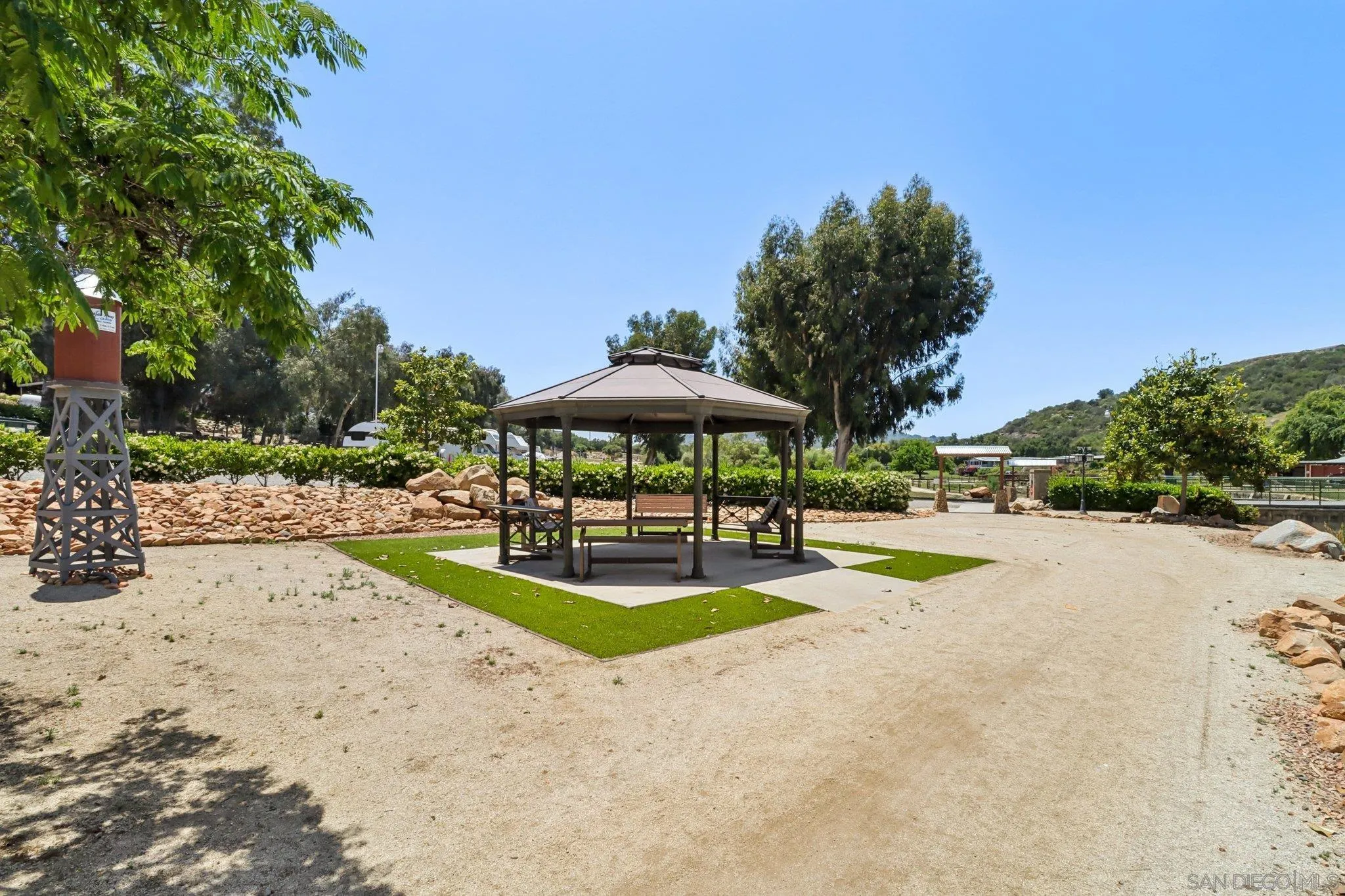28890 Lilac Road, Unit 97 Valley Center, CA 92082 - Photo 42 of 51 a view of a swimming pool with a table and chairs under an umbrella