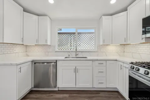 a bathroom with a granite countertop double vanity sink a mirror and a shower