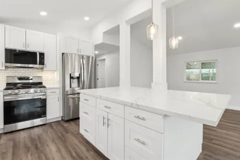 a kitchen with white cabinets and stainless steel appliances