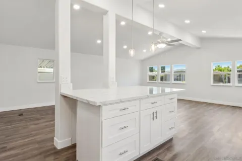 an empty room with wooden floor window and ceiling fan