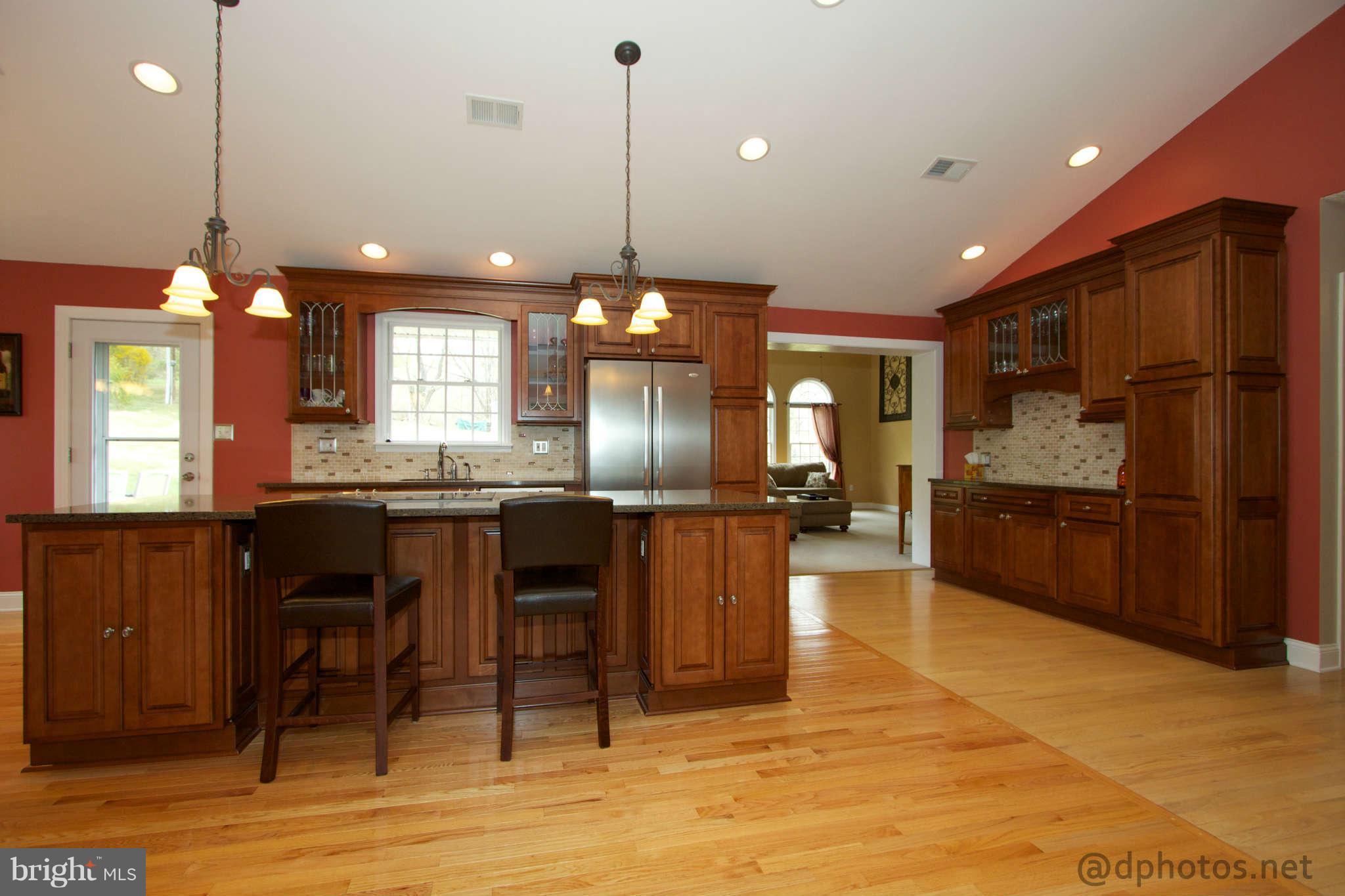 1315 Murgatroyd Road Fallston, MD 21047 - Photo 5 of 30 a kitchen with stainless steel appliances kitchen island granite countertop a refrigerator a oven a sink a dining table and chairs with wooden floor