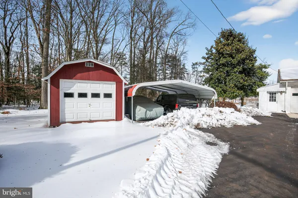 a front view of a house with a yard covered in snow