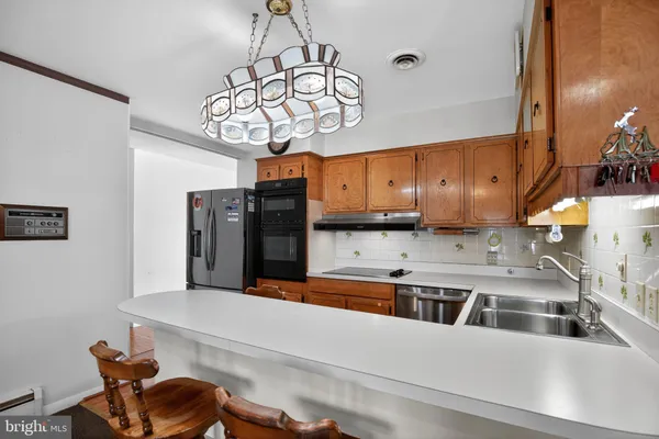 a kitchen with stainless steel appliances kitchen island granite countertop a sink and cabinets