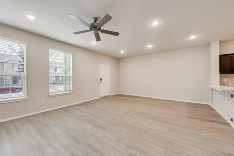 a view of an empty room with wooden floor