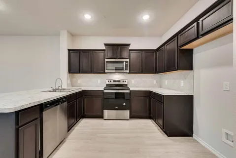 a kitchen with granite countertop stainless steel appliances and wooden cabinets