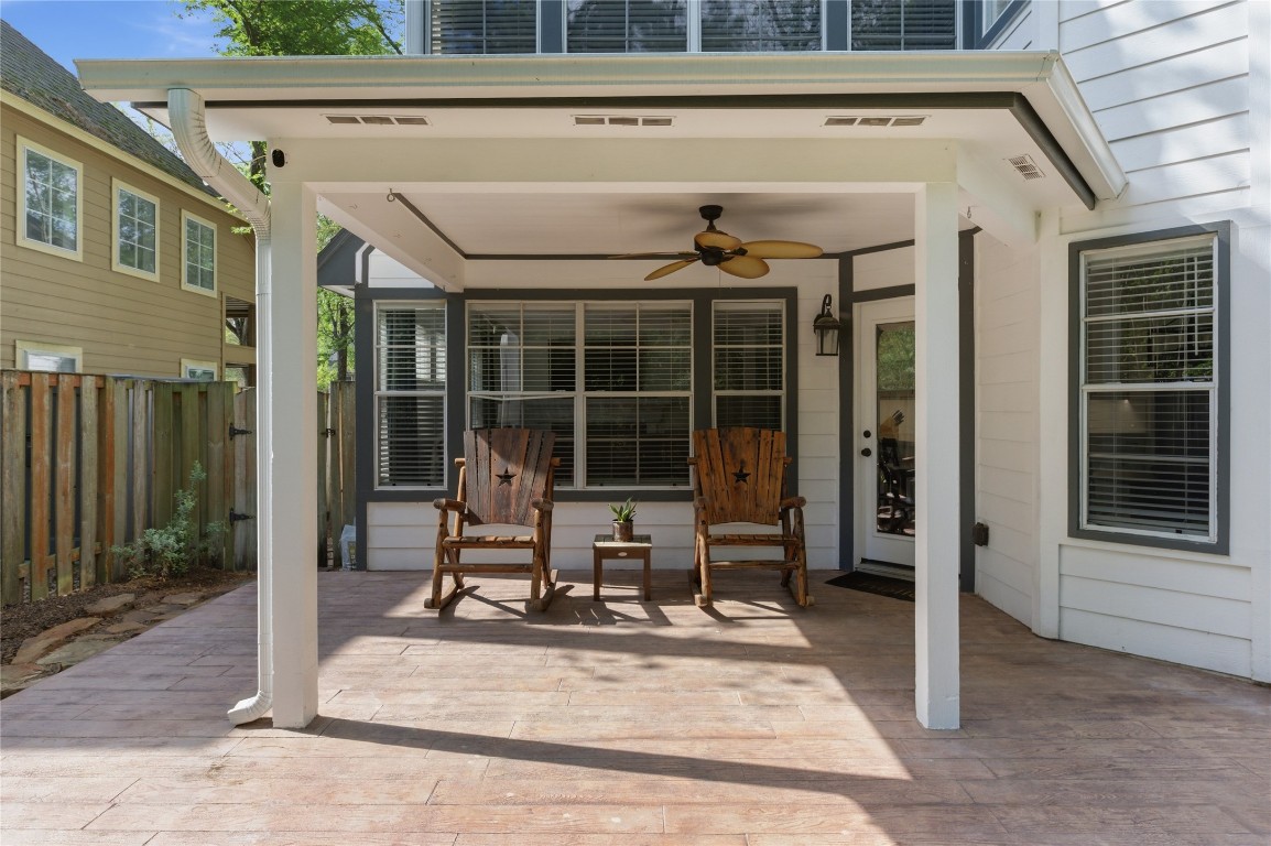 50 East Greywing Circle Spring, TX 77382 - Photo 35 of 37 Covered patio with a ceiling fan. It's surrounded by a wooden fence, offering a comfortable outdoor living space.