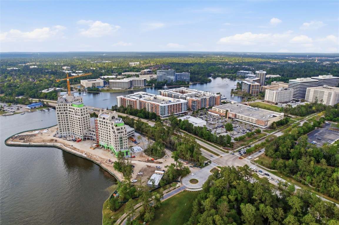 50 East Greywing Circle Spring, TX 77382 - Photo 36 of 37 Modern urban development surrounded by greenery and water views. It features a mix of residential and commercial buildings, with ongoing construction indicating growth. The area is well-connected by roads and offers a blend of nature and city living.