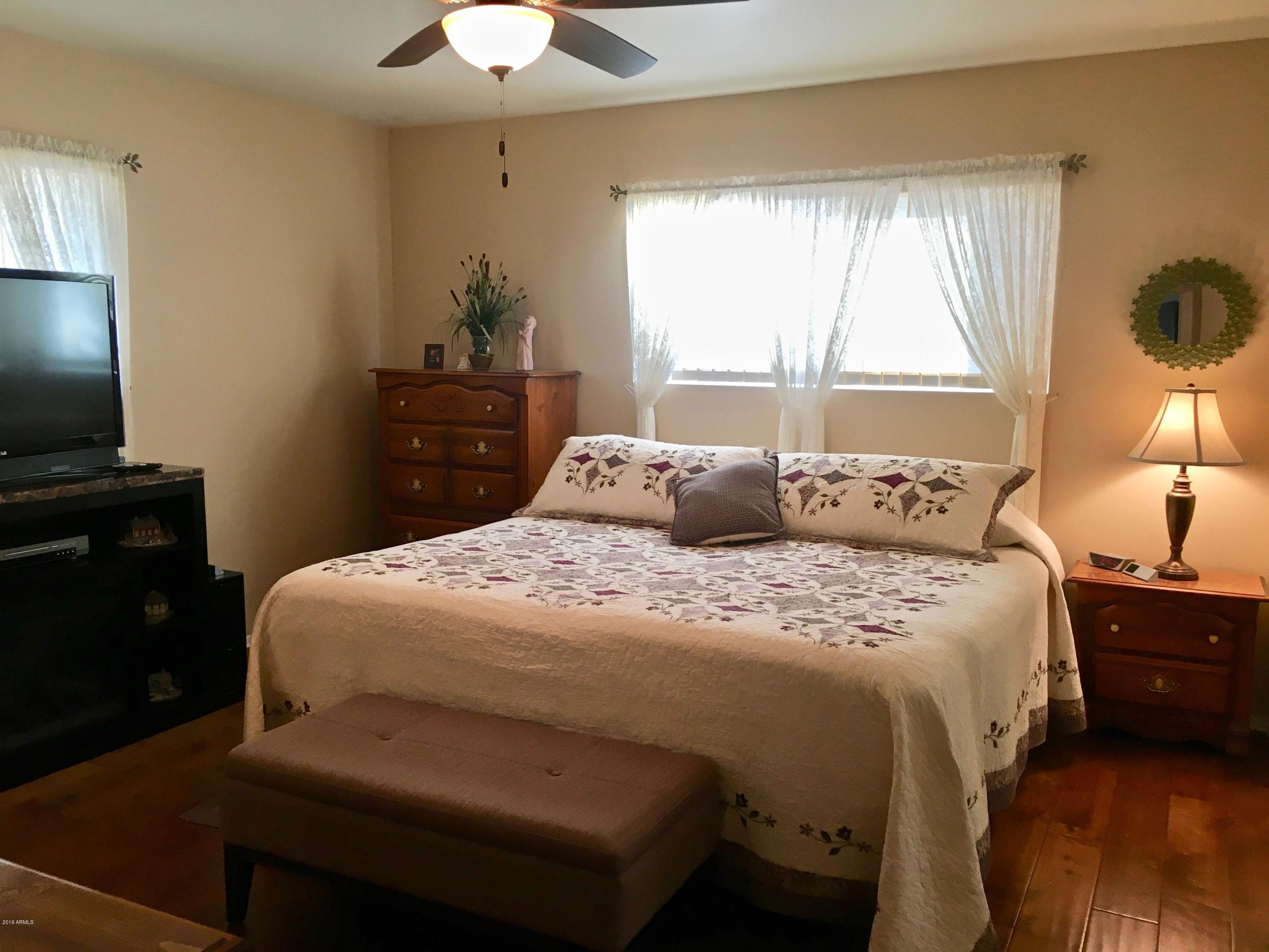5402 East Decatur Street Mesa, AZ 85205 - Photo 13 of 37 a bedroom with a bed and a chandelier