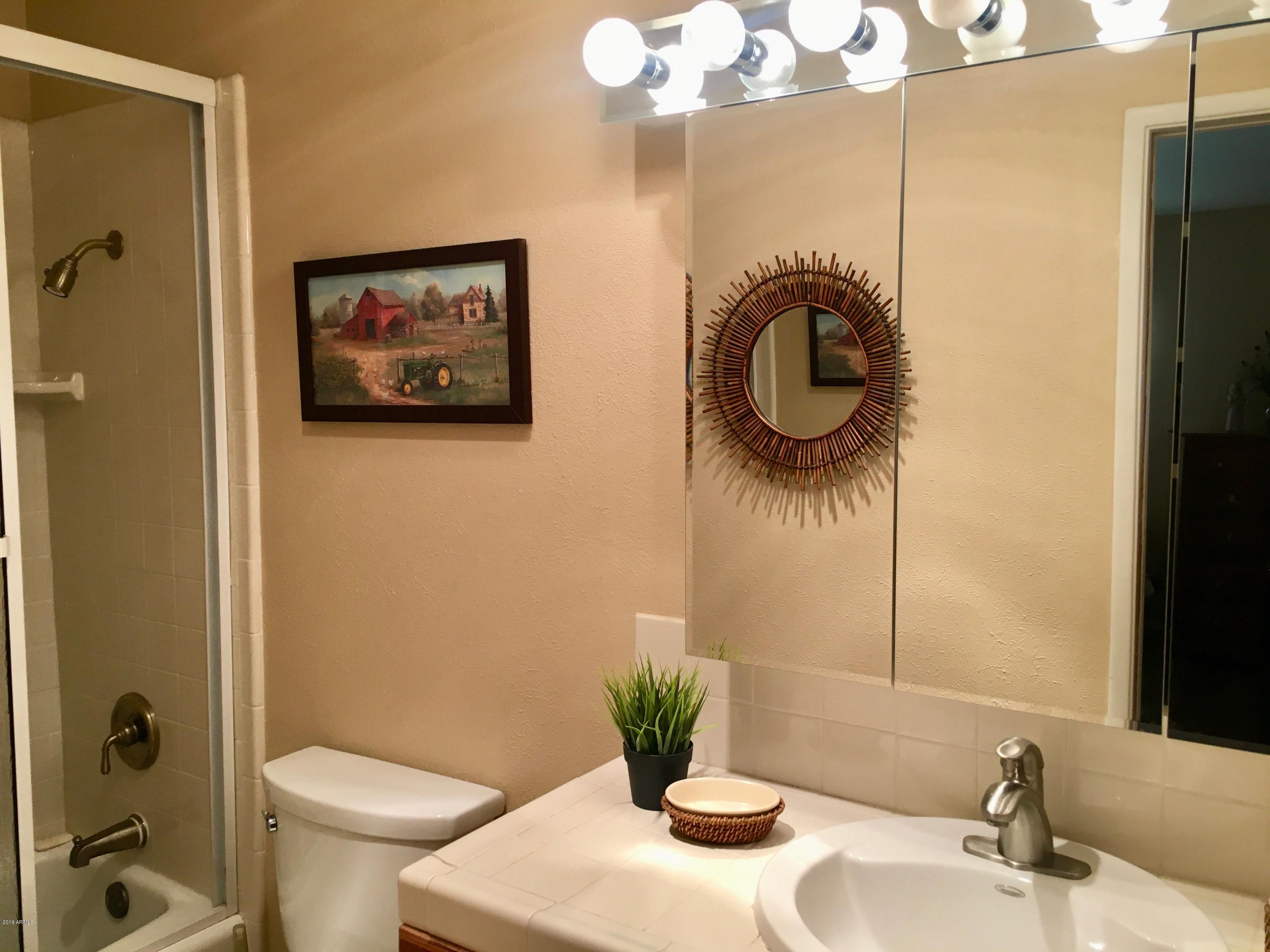 5402 East Decatur Street Mesa, AZ 85205 - Photo 17 of 37 a bathroom with a granite countertop sink a toilet and a mirror