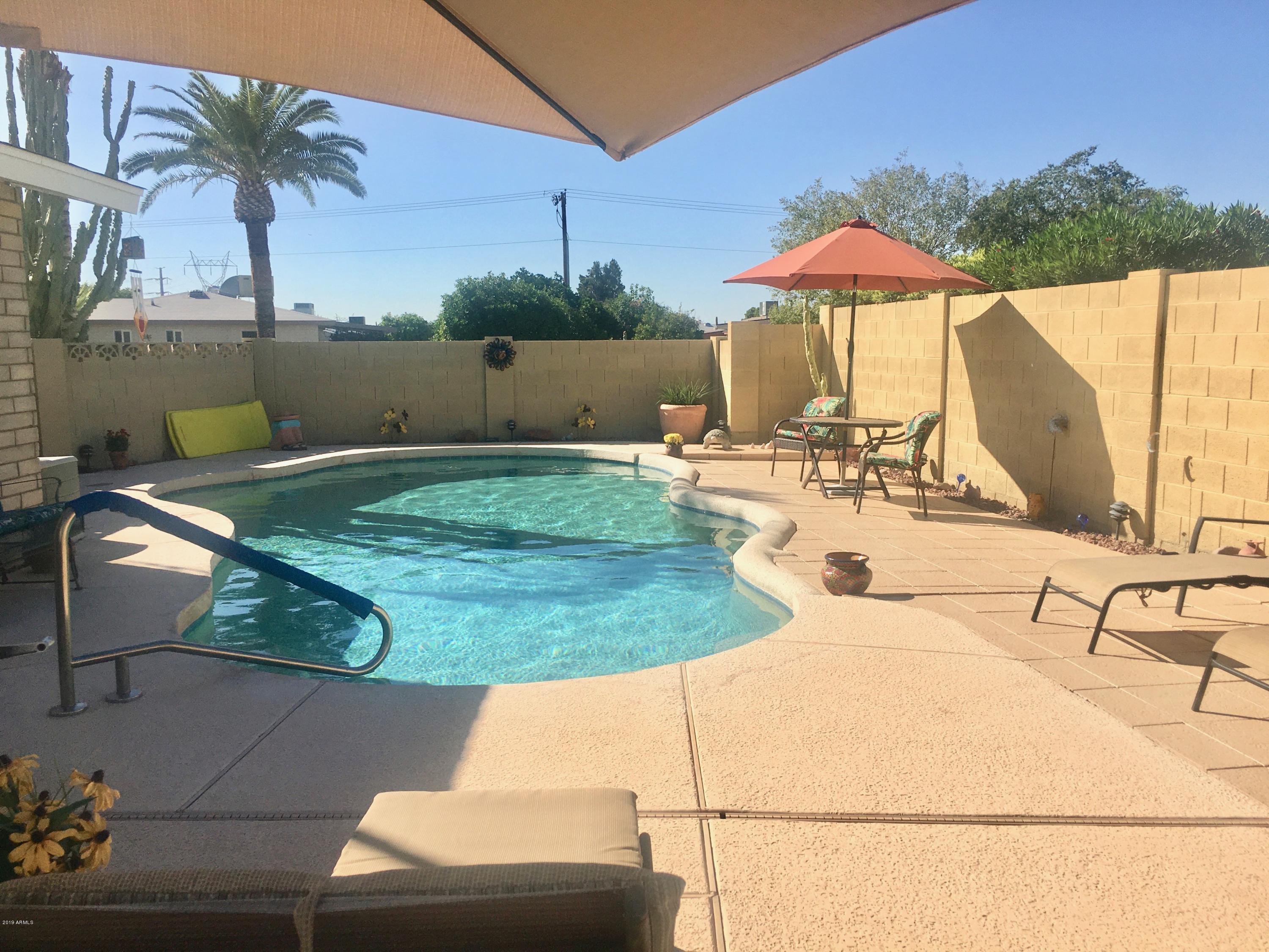 5402 East Decatur Street Mesa, AZ 85205 - Photo 25 of 37 a view of a patio with a table and chairs under an umbrella
