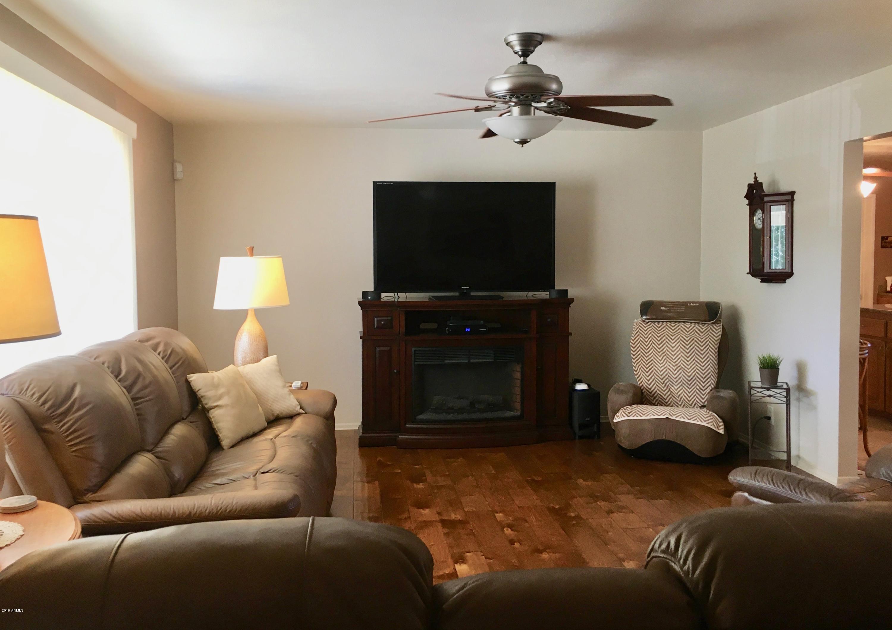 5402 East Decatur Street Mesa, AZ 85205 - Photo 6 of 37 a living room with furniture and a flat screen tv