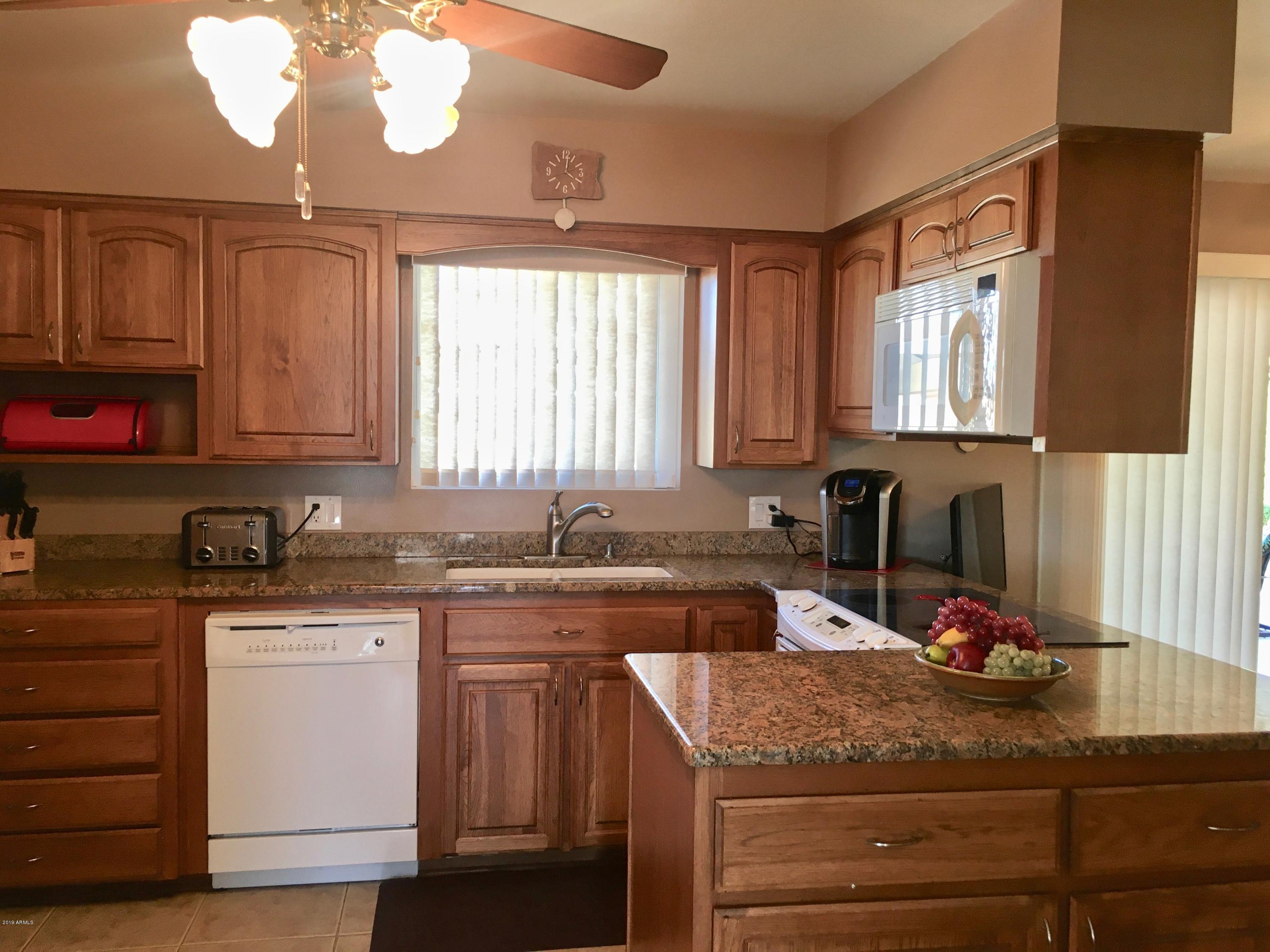 5402 East Decatur Street Mesa, AZ 85205 - Photo 8 of 37 a kitchen with a sink dishwasher a stove and a microwave oven